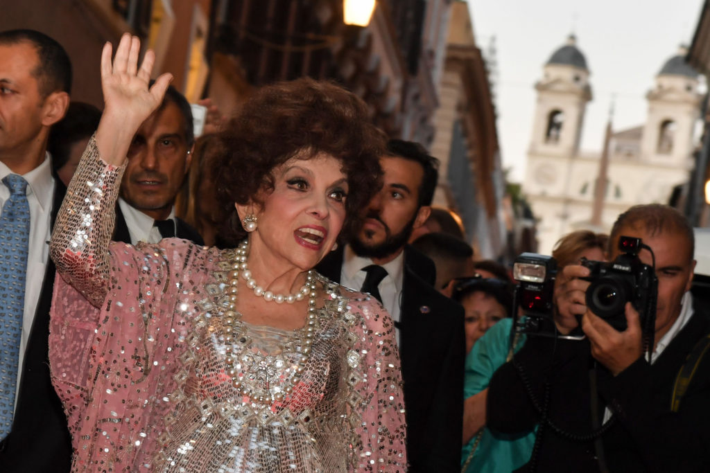 Italian actress Gina Lollobrigida waves as she poses for photographers in Via Condotti to celebrates her 90th birthday, on the red carpet in front of Piazza di Spagna, in central Rome, on July 4, 2017. / AFP PHOTO / ANDREAS SOLARO